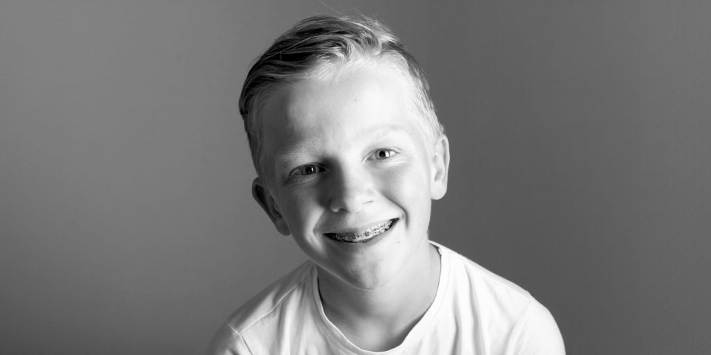 Smiling boy with braces, having early orthodontic intervention
