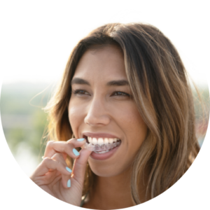 Smiling girl holding Invisalign clear aligners